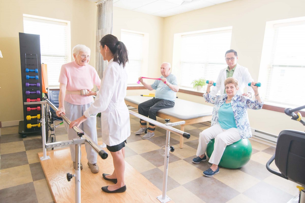 Elderly individuals participating in a physical therapy session with healthcare professionals.