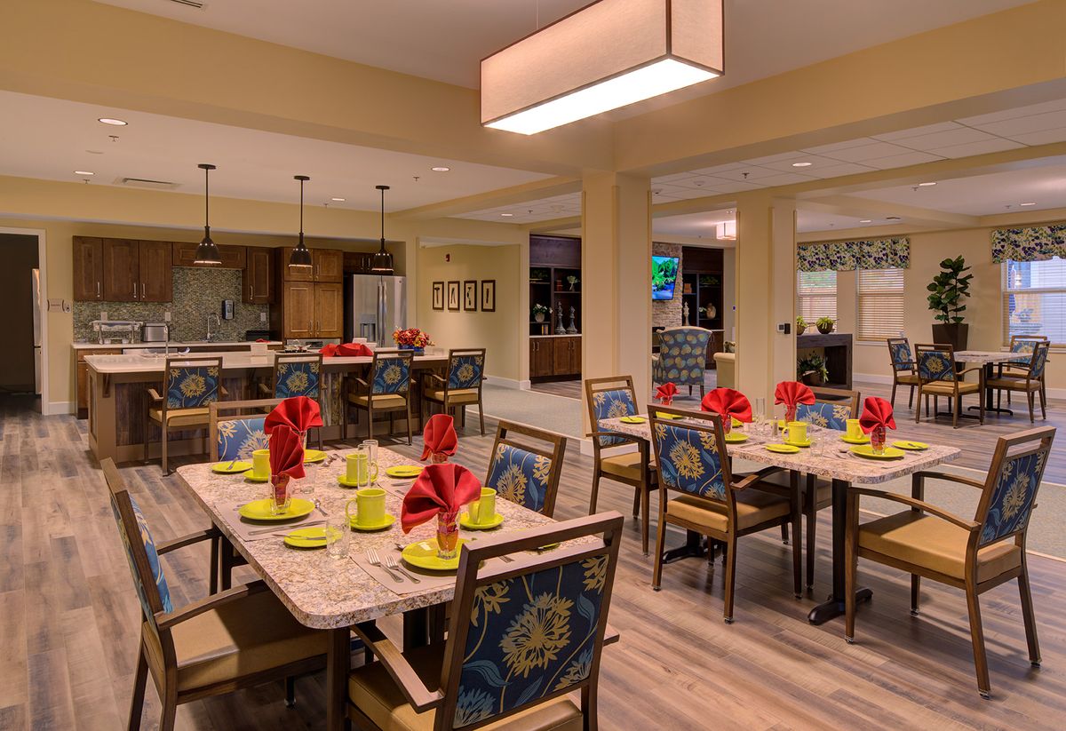 A beautifully arranged dining area with tables set for guests, featuring decorative elements and ambient lighting.