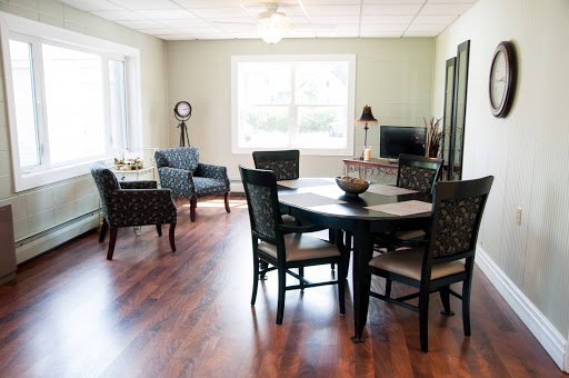 A cozy and well-lit dining area featuring a round table and comfortable seating, perfect for gatherings.