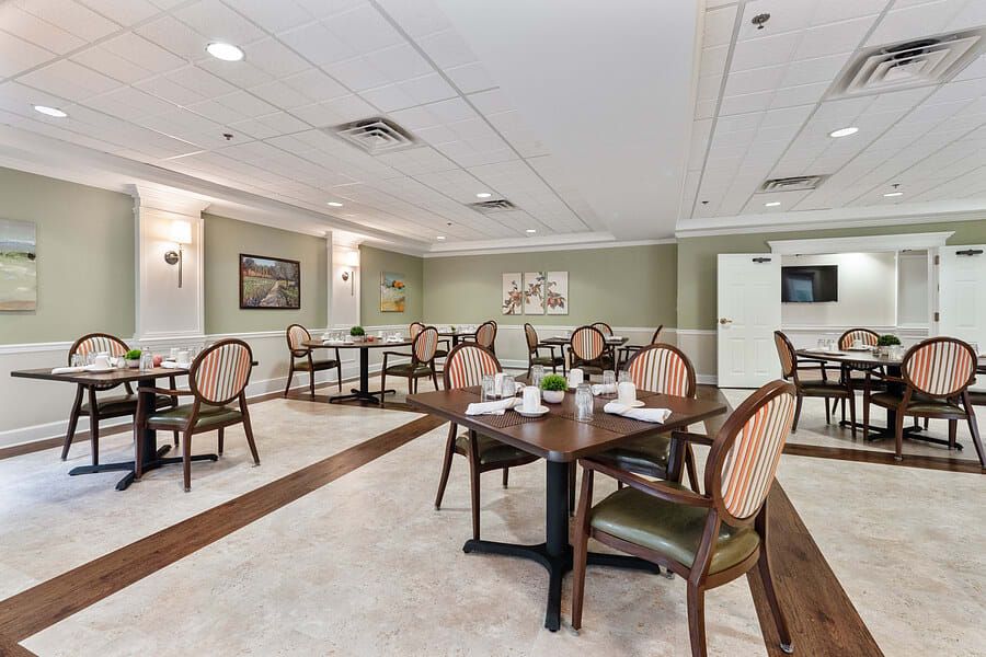 An elegantly furnished dining room with neatly arranged tables and chairs.