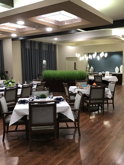 A well-lit restaurant dining area with elegantly arranged tables and chairs.