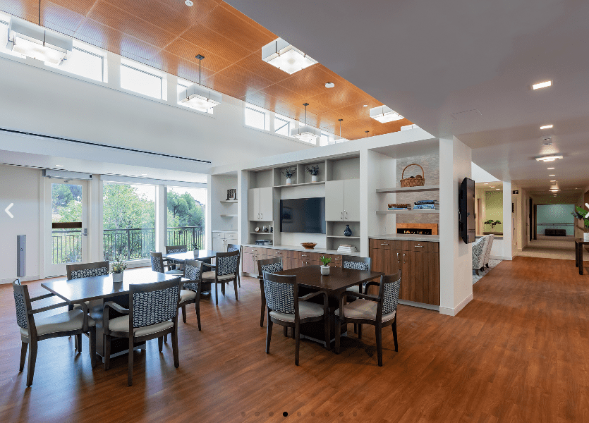 A modern dining area with wood flooring and ample natural light.