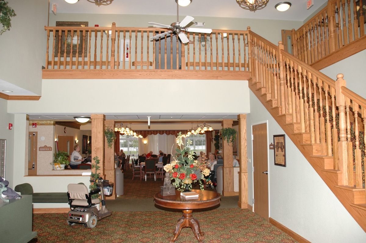 A cozy lobby area with a staircase and decorative flowers.