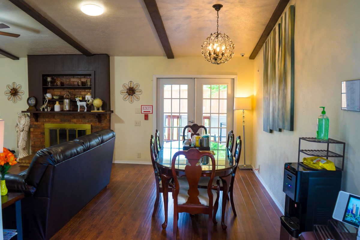 A cozy dining room with a wooden table and chairs, featuring warm lighting and elegant decor.