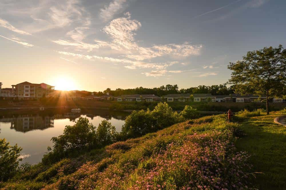 A picturesque sunset over a tranquil lake surrounded by lush greenery.
