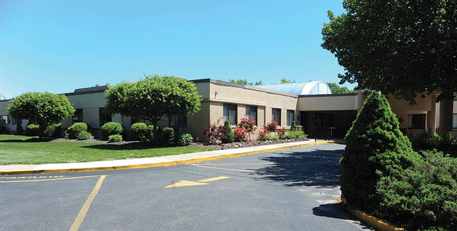 A single-story building with landscaped surroundings and a driveway.