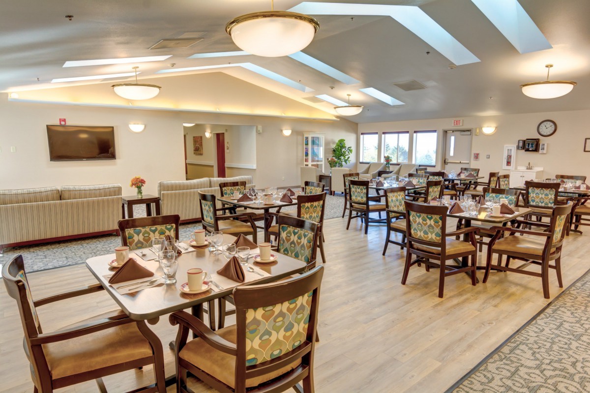 A well-lit dining room with neatly arranged tables and chairs, showcasing a cozy atmosphere.