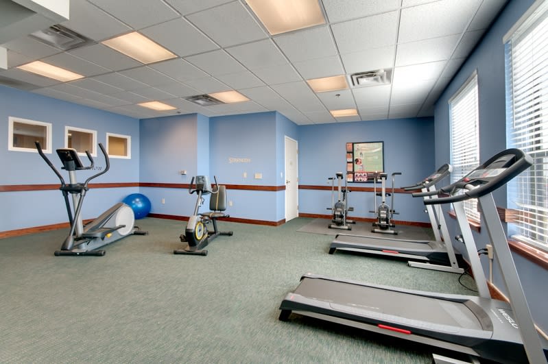 A small fitness room with exercise equipment including treadmills and stationary bikes.