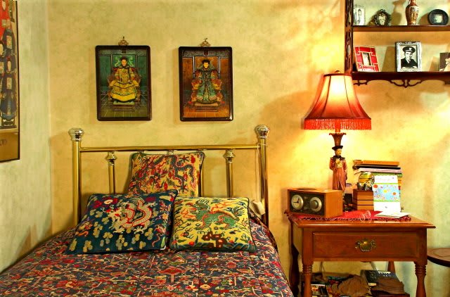 A cozy bedroom with colorful bedding and warm lighting.