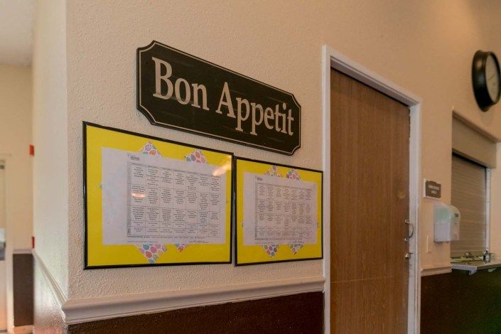 A Bon Appetit sign hangs above framed menus on a wall.