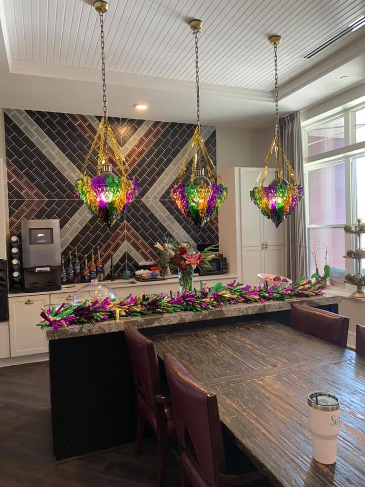 A modern kitchen with colorful pendant lights and elegant flower arrangements.