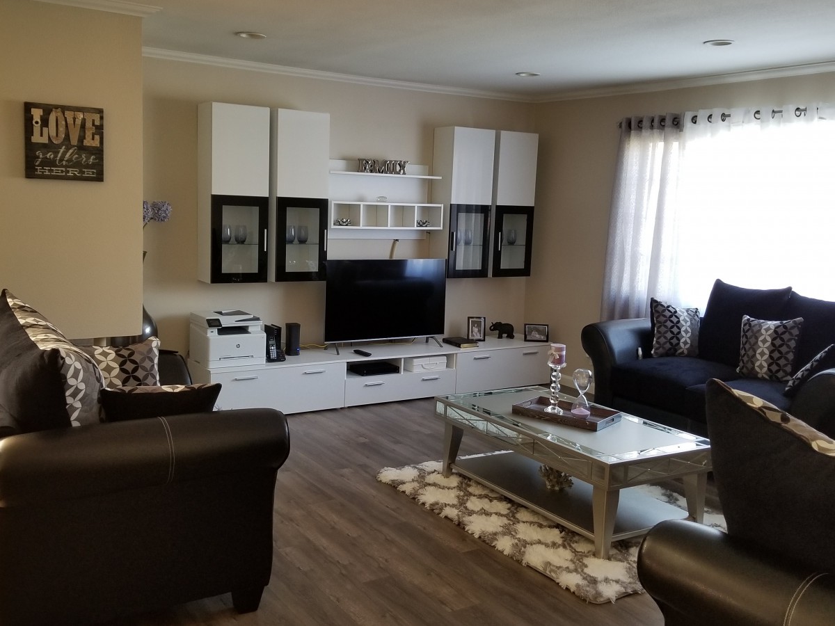 A modern living room with a flat-screen TV, cozy sofas, and a stylish coffee table.