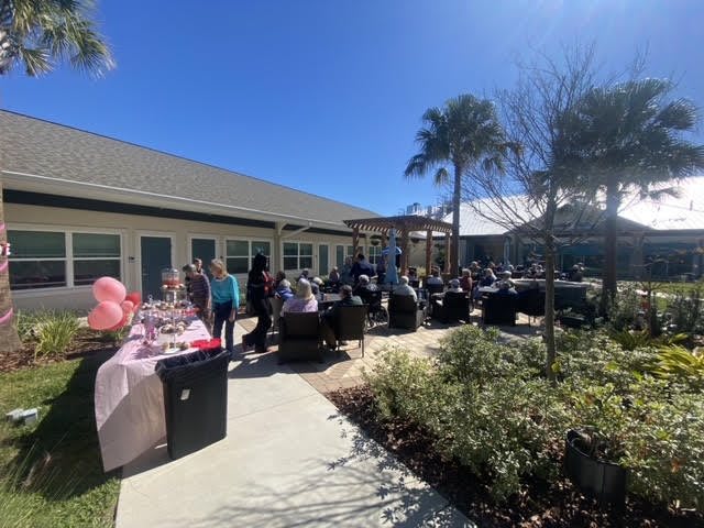 A sunny outdoor gathering with people enjoying the event under clear skies.