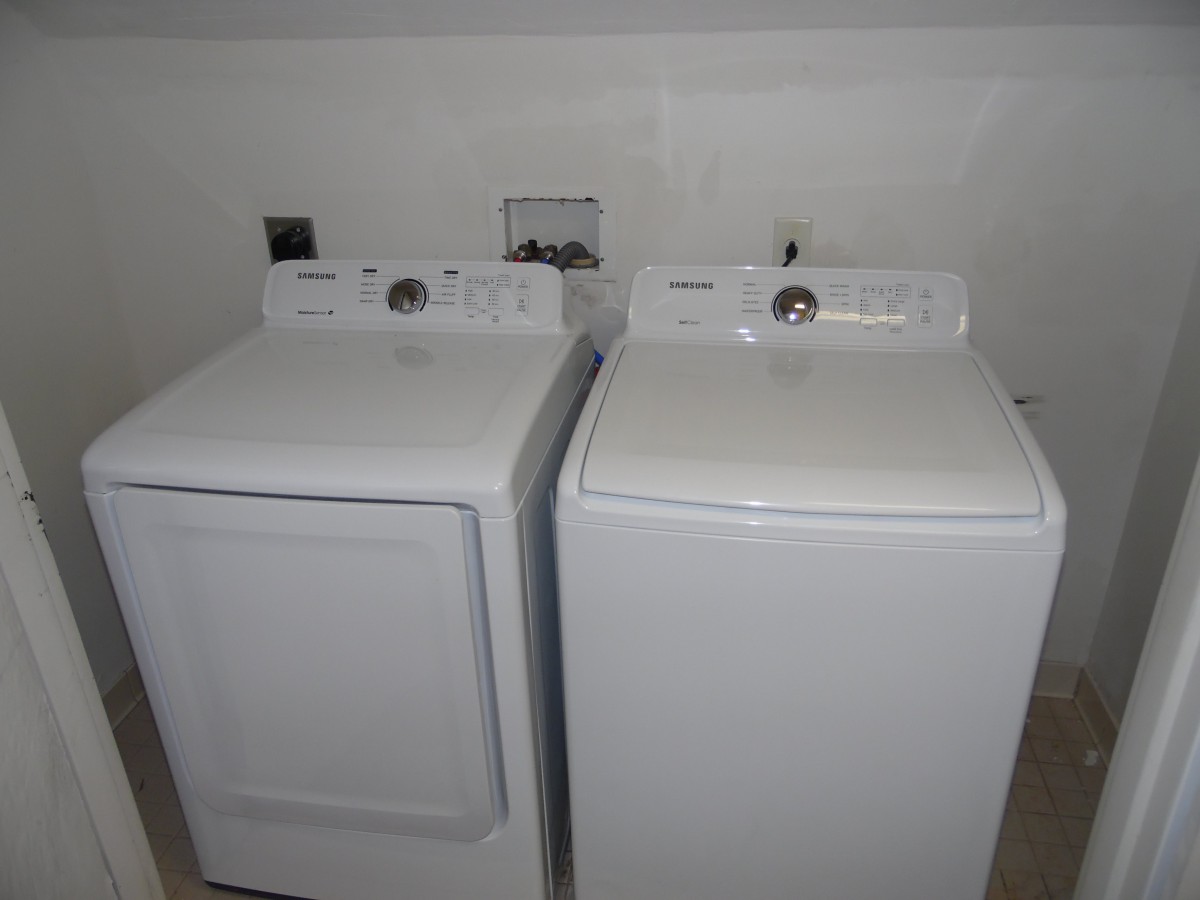 A laundry room featuring a white washing machine and dryer set.