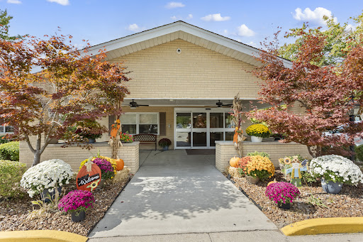 A beautiful entrance to a welcoming residence, adorned with vibrant flowers and lush landscaping.