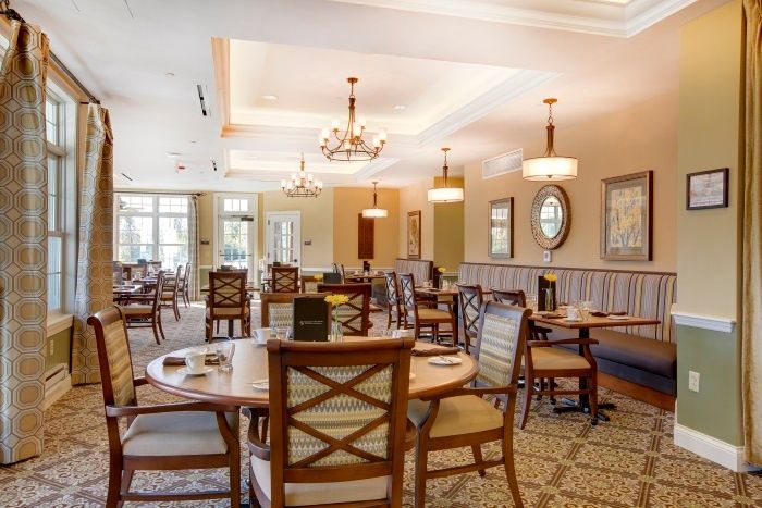 A well-decorated dining area with elegant chandeliers and neatly arranged tables and chairs.