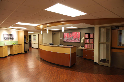 A modern medical reception area featuring a curved desk and contemporary decor.