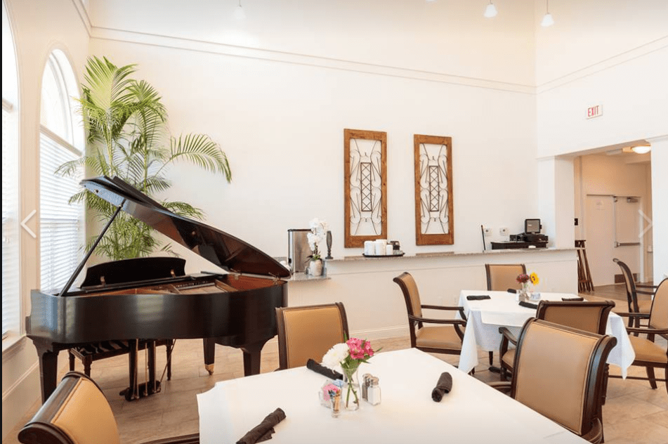 Elegant restaurant dining area featuring a grand piano and white tablecloths.