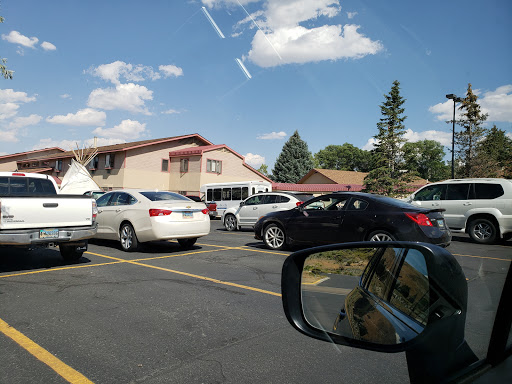 A busy parking lot filled with cars and a view of nearby buildings under a clear blue sky.