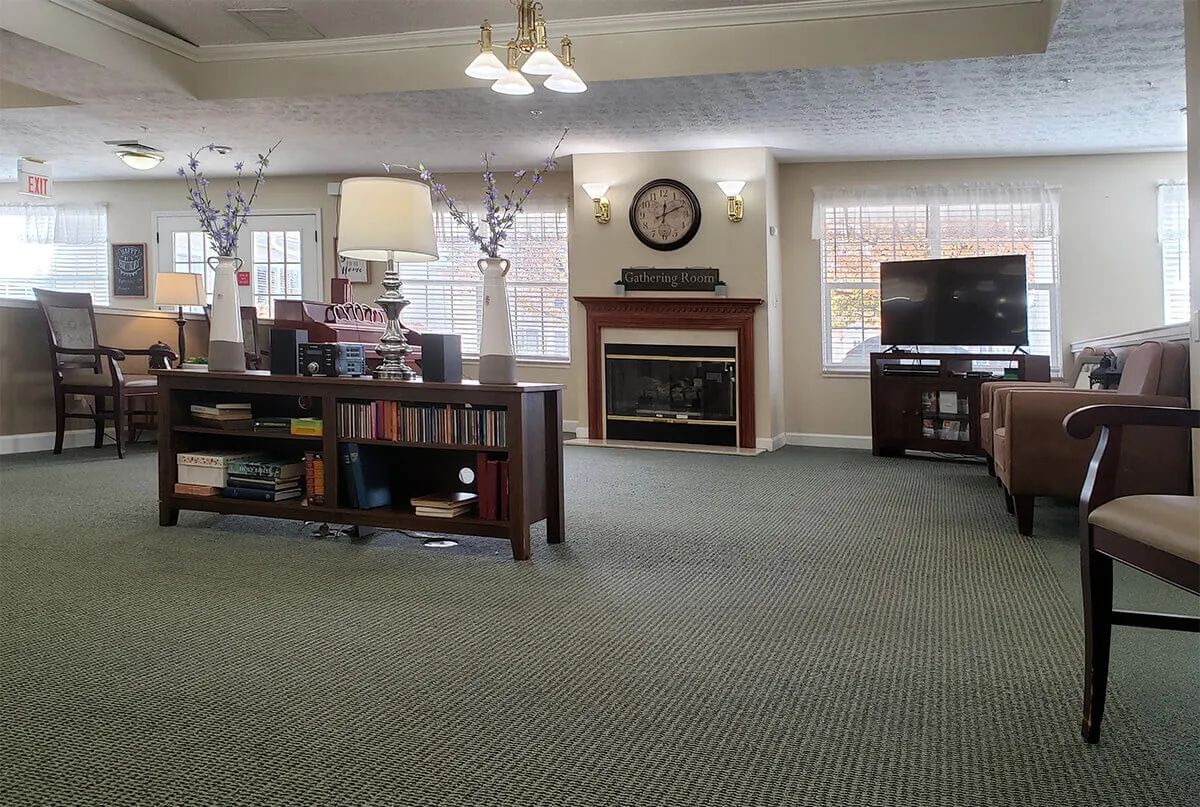 A cozy living room featuring a fireplace, television, and bookshelves.