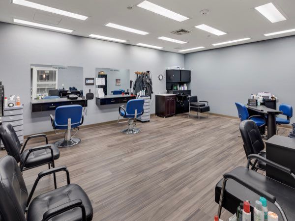 An empty hair salon with multiple styling stations and chairs.