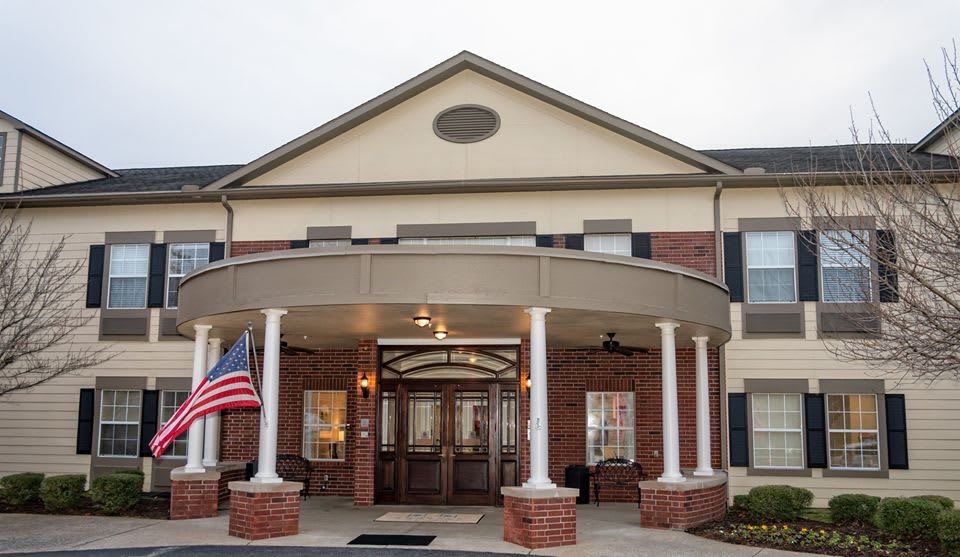 An entrance to a building featuring columns and an American flag.