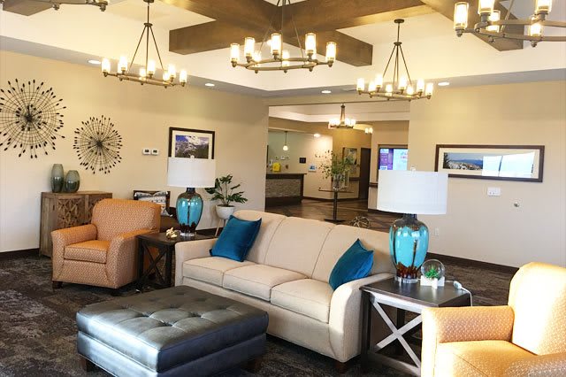 A well-decorated lobby with cozy seating and elegant chandeliers.
