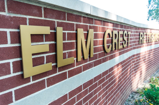 A close-up view of the Elm Crest sign mounted on a brick wall.