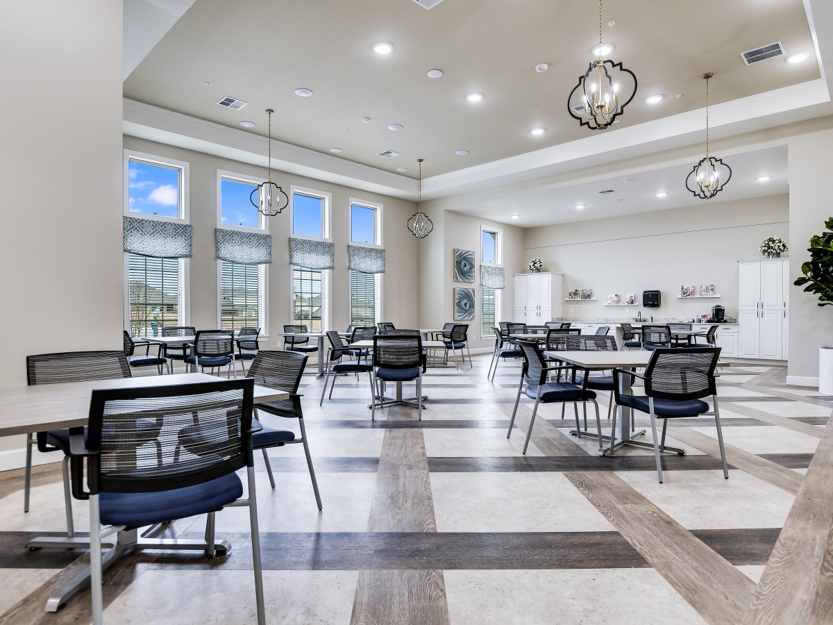 A spacious and modern dining area with contemporary furniture and large windows providing ample natural light.
