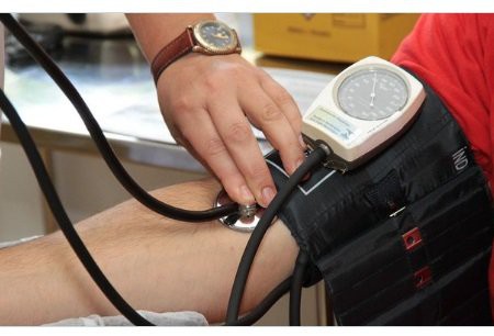 A healthcare professional measuring blood pressure using a sphygmomanometer.