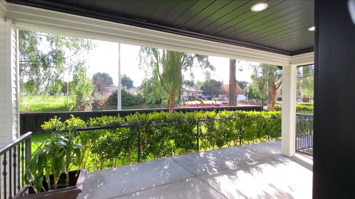 A sunny patio with a view of lush greenery and a garden.
