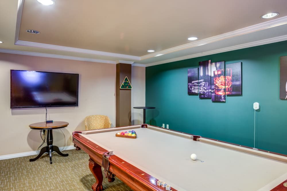 A modern game room featuring a pool table, television, and stylish decor.