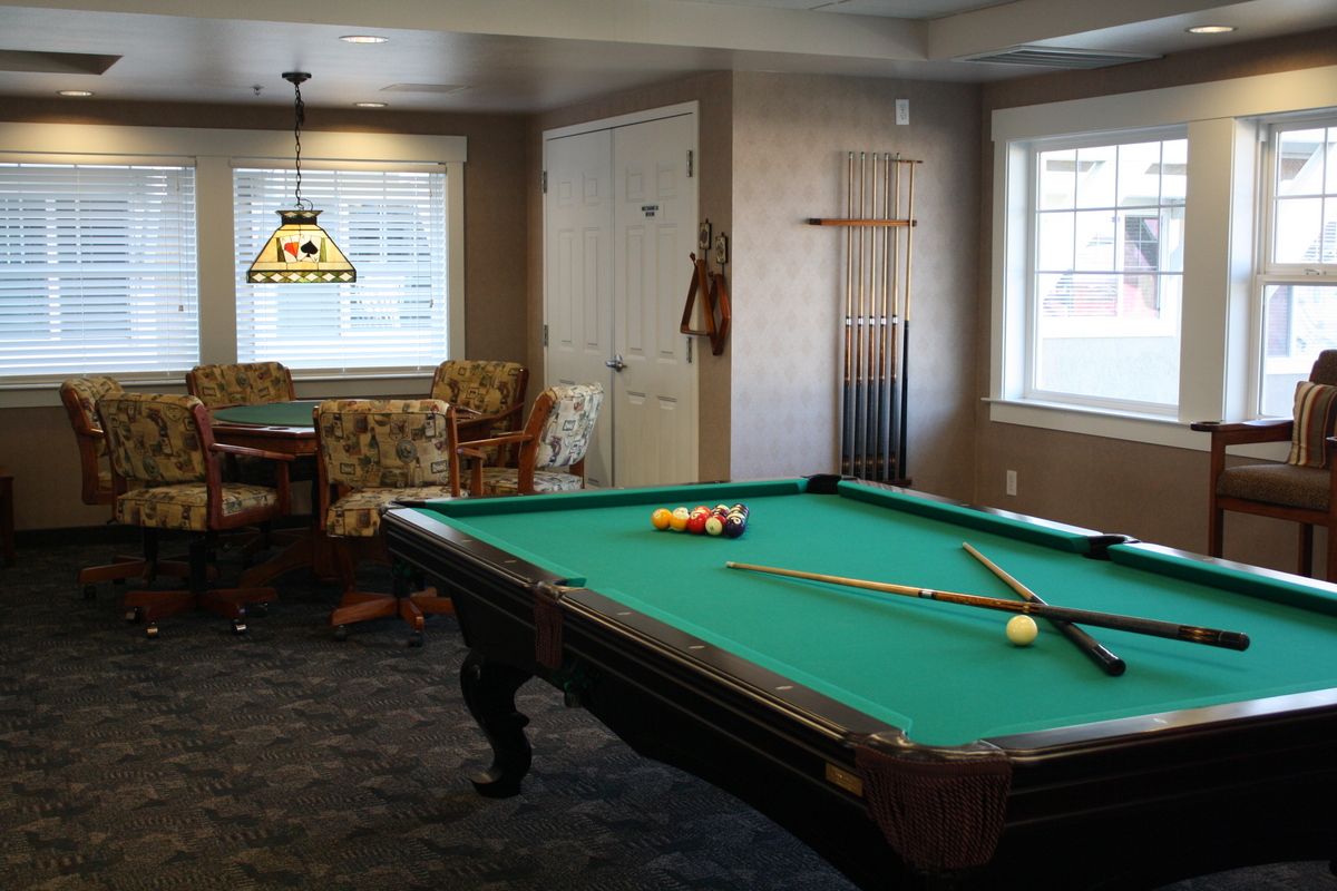 A cozy game room featuring a pool table and seating area.