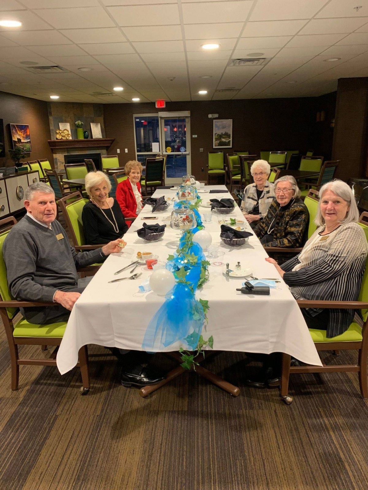 A group of people enjoying a meal together at a decorated table.