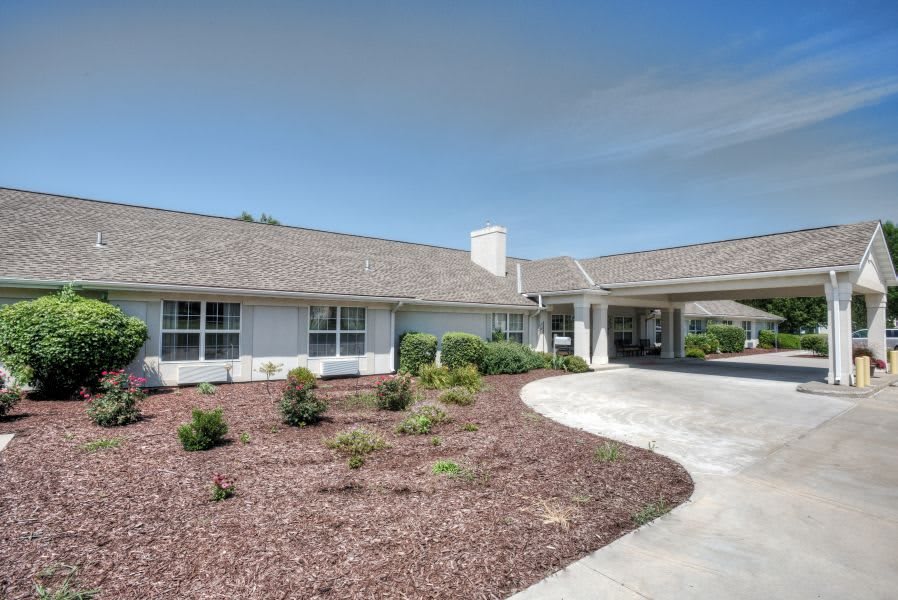 A suburban home with well-maintained landscaping and a curved driveway.