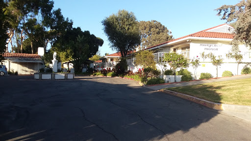 A peaceful residential area showcasing well-maintained gardens and trees along a winding pathway.