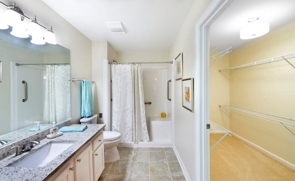 A clean and bright bathroom with a shower, sink, and toilet.