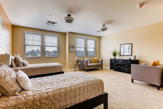 A spacious bedroom with twin beds and a cozy seating area.
