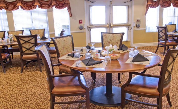 A neatly set dining table in a well-decorated interior, ready for guests.