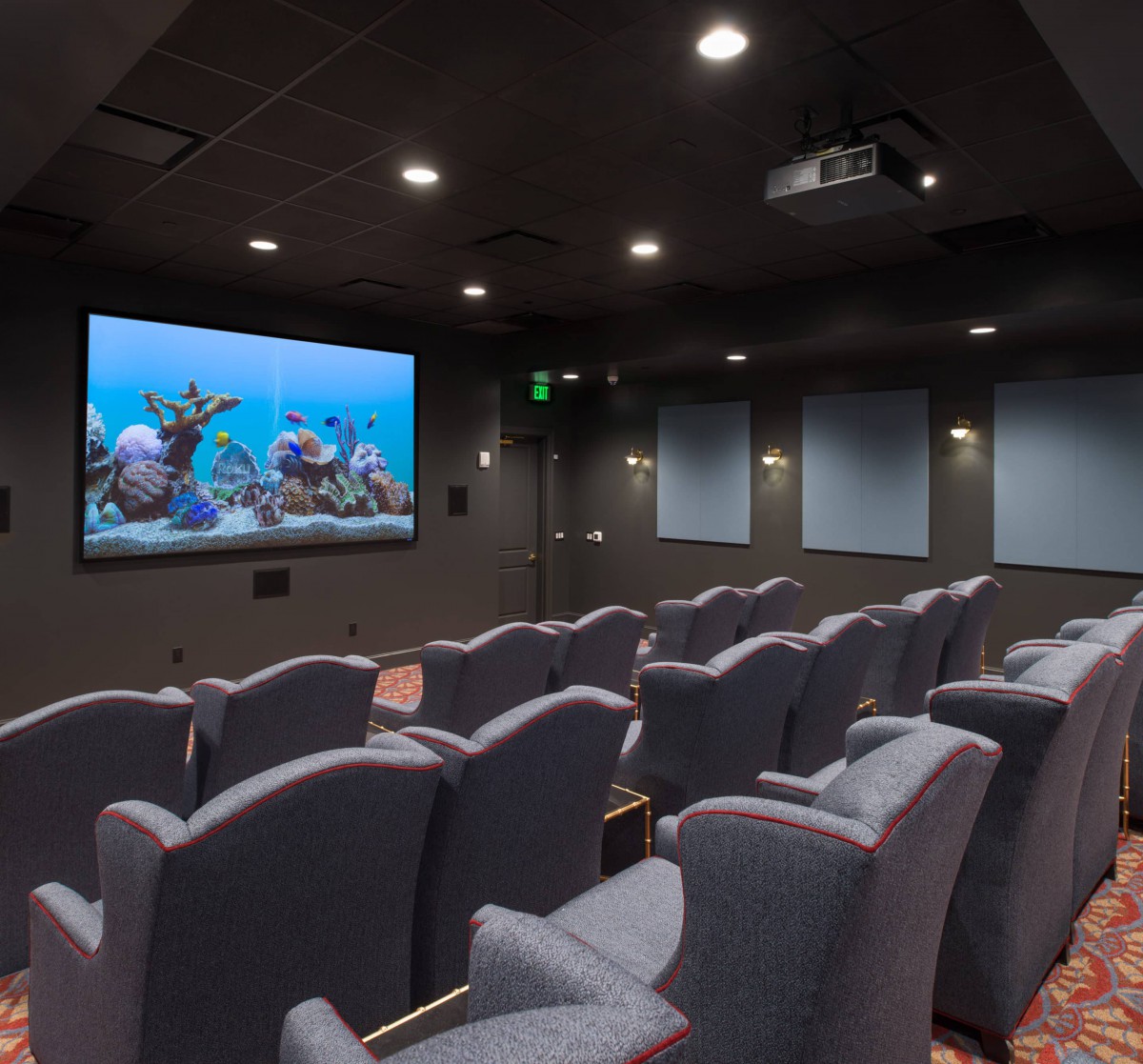 A cozy home theater room with comfortable seating and a large screen.