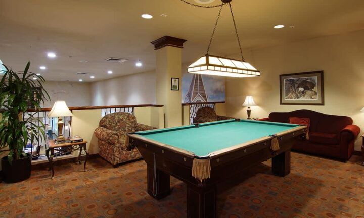 A cozy game room featuring a pool table and comfortable seating.