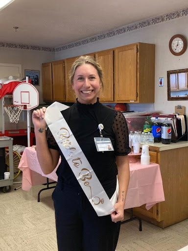 A cheerful celebration with someone wearing a sash, marking a special occasion.