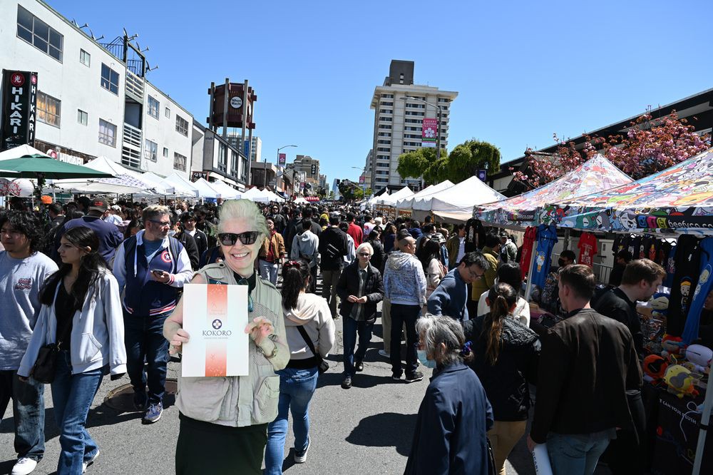 A bustling outdoor market with people enjoying a sunny day.