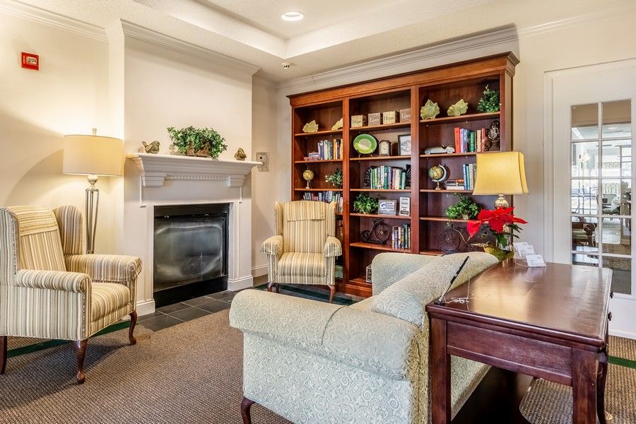 A cozy living room with a fireplace, bookshelf, and comfortable seating.