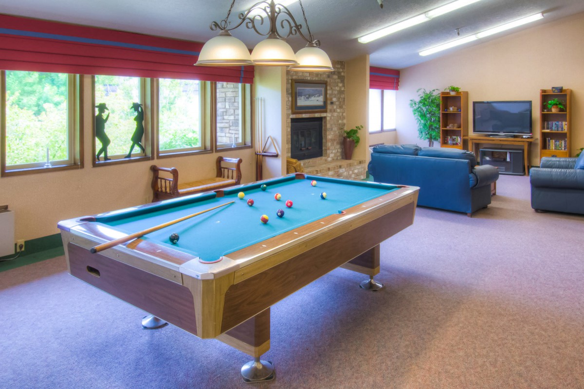 A recreational room featuring a pool table and cozy seating area.