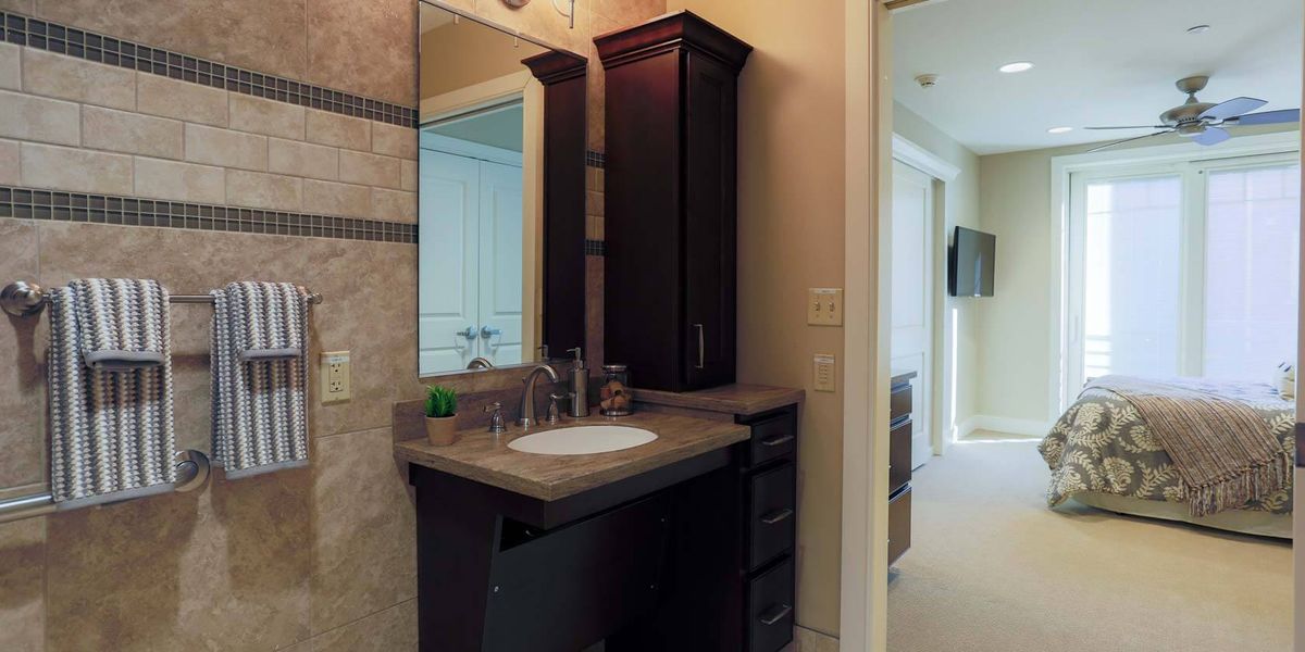 A modern bathroom with a sink, mirror, and dark wood cabinetry.