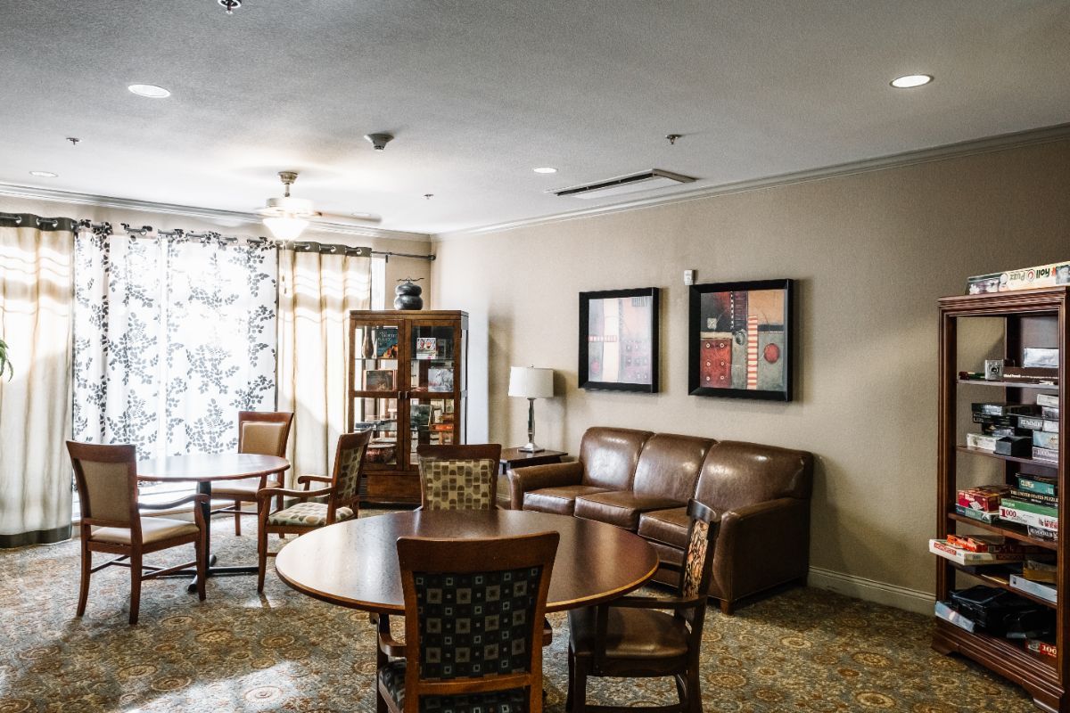 A cozy living room with a round table, chairs, and a leather sofa.