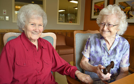 Two elderly women enjoying each other's company in a cozy setting.