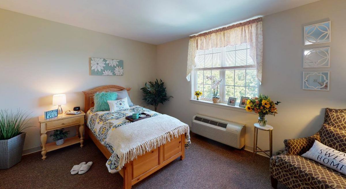 A cozy bedroom with a single bed and decorative elements, including plants by the window.