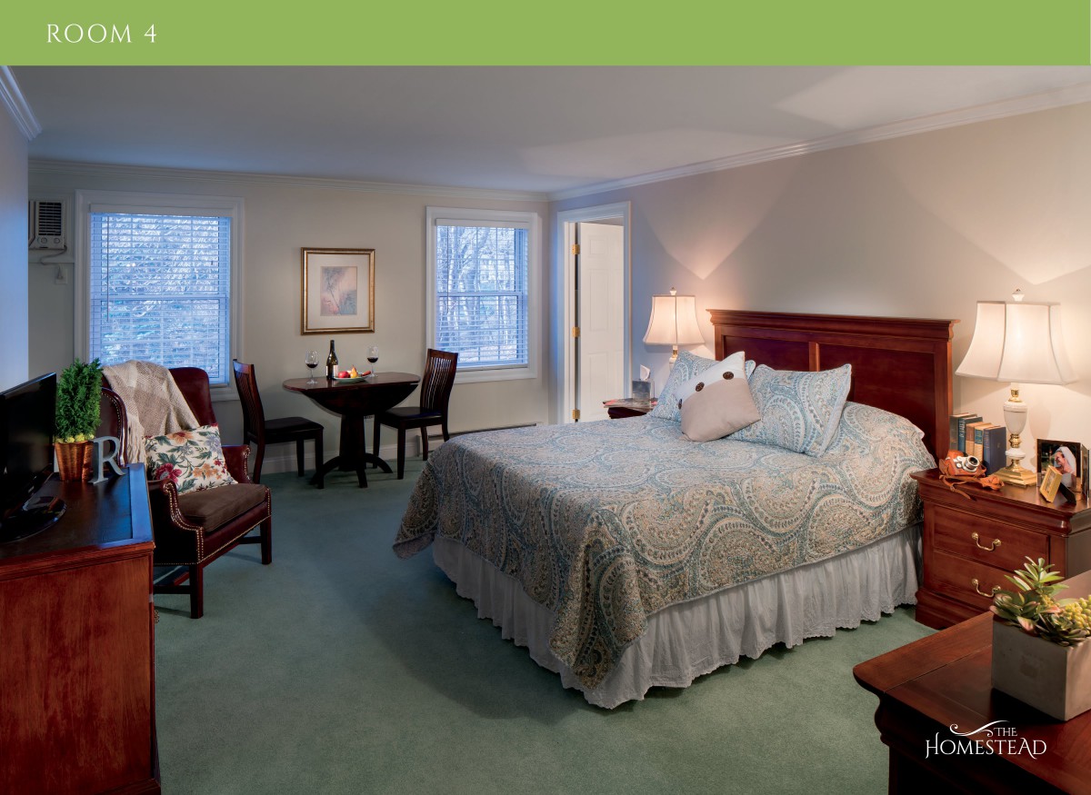 A spacious bedroom with a large bed, seating area, and cozy lighting.